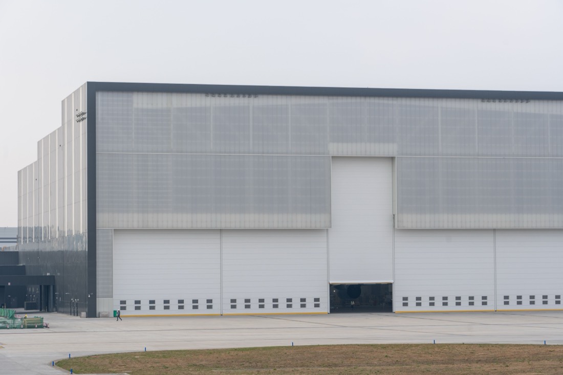 Large windowless industrial building with tall loading doors