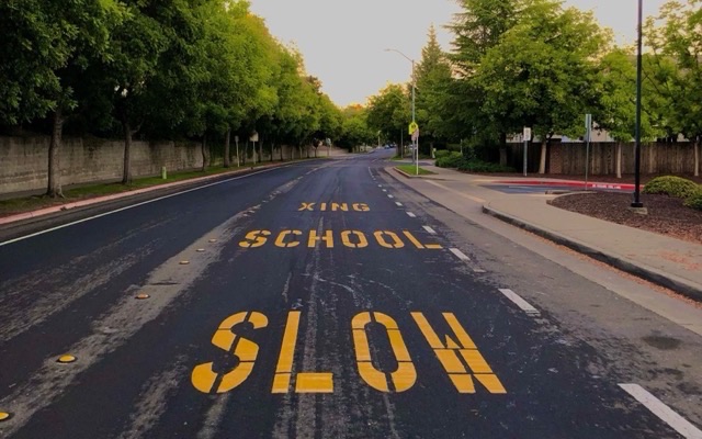 School crossing with SLOW SCHOOL XING painted on the road