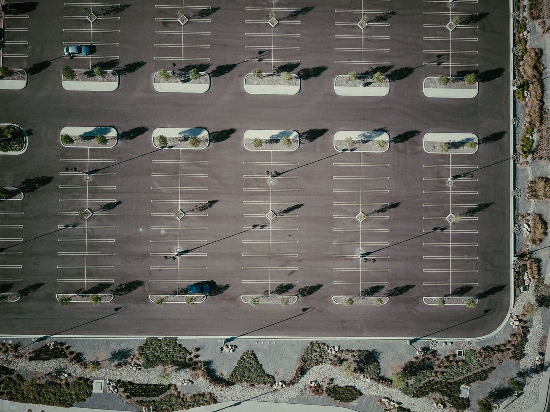 Aerial view of a large parking lot with pole lights